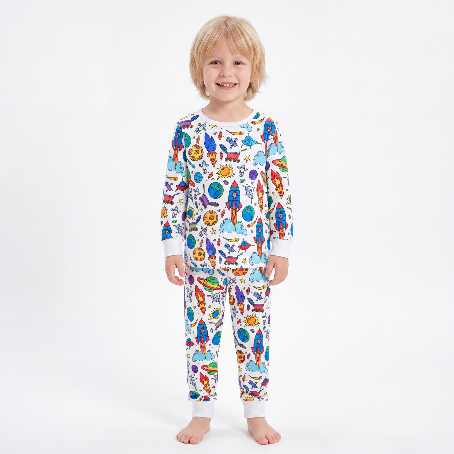 Boy wearing The Coloring Pajama in the Space & Galaxy print, fully colored in with vivid rockets and planets