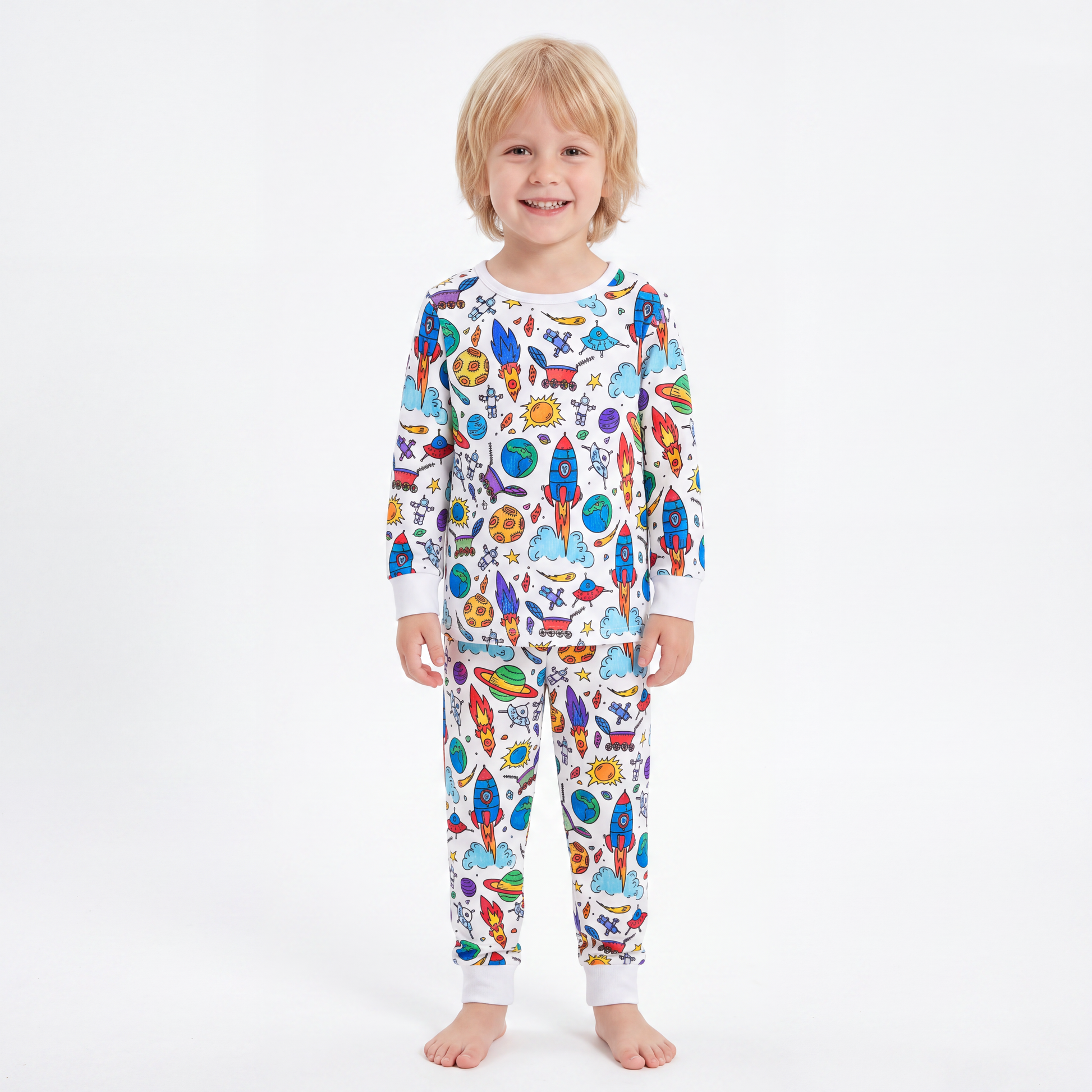Boy wearing The Coloring Pajama in the Space & Galaxy print, fully colored in with vivid rockets and planets
